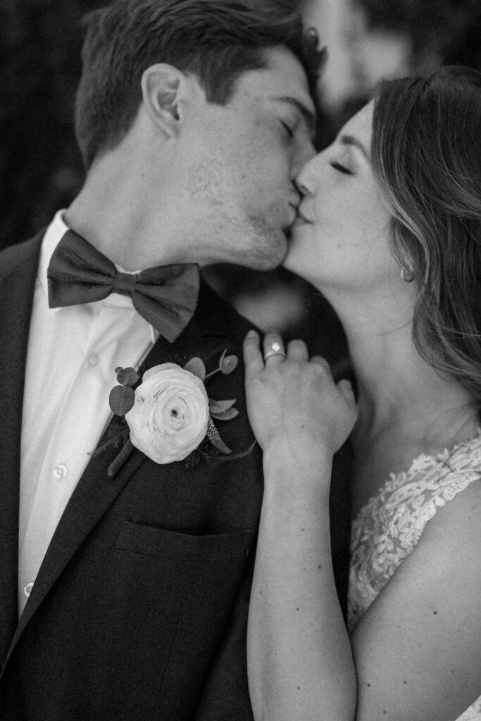 Bride and groom kissing on their wedding day in black and white