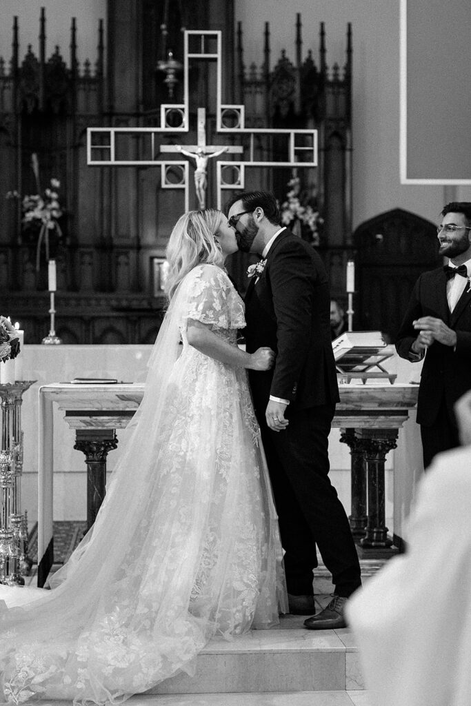 church ceremony photo in black and white, bride and groom first kiss in church 